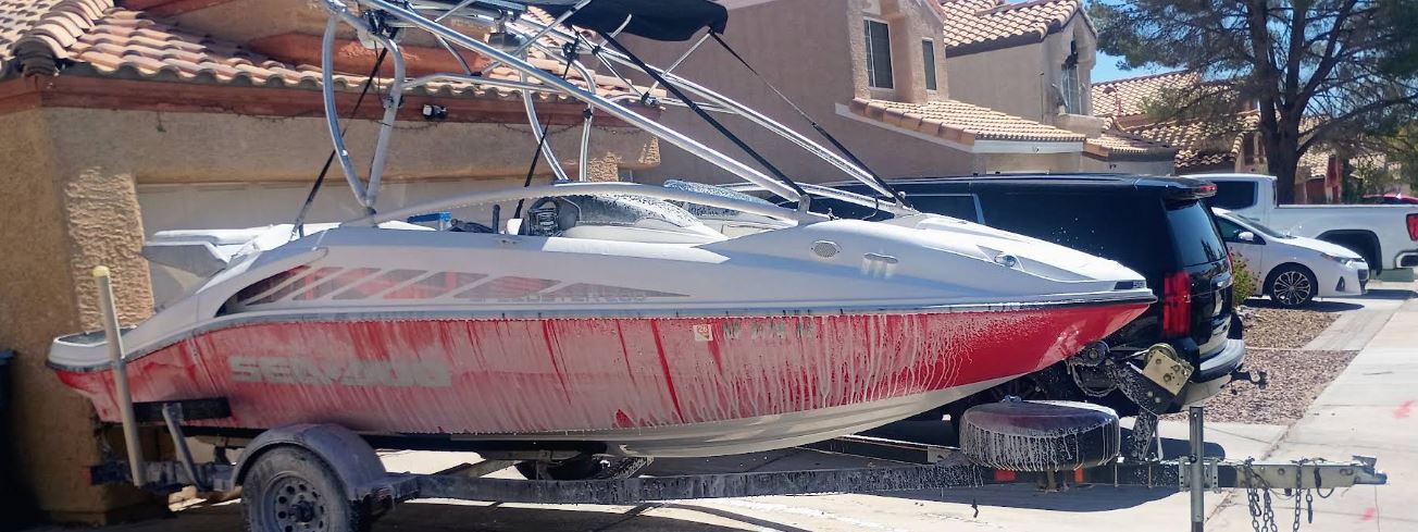 Boat and trailer covered in foam in a driveway